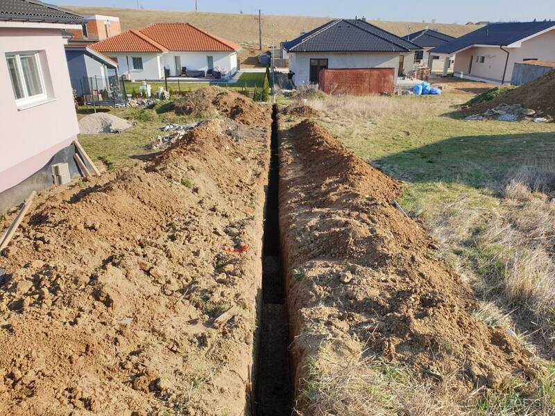 Dlhá úzka ryha pre prípojky vykopaná cez pozemok rodinného domu